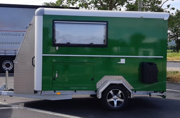 Groene caravan op maat met aluminium accenten en een zijraam.